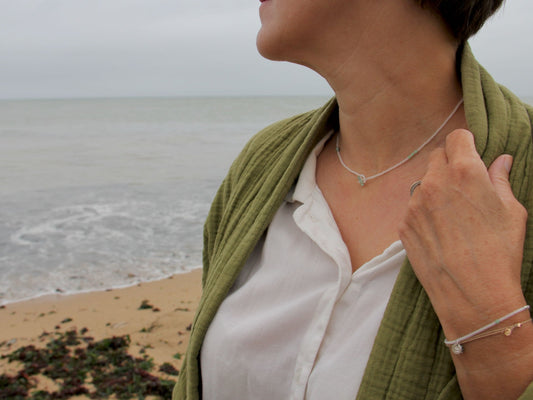 Collier lasso Brume porté sur une chemise blanche, perles cristal et angélites vertes