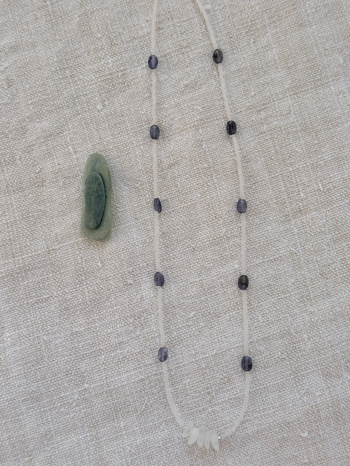 Collier court Brume en entier, iolites ovales et perles transparentes mat, posé sur du lin — fait main en Normandie