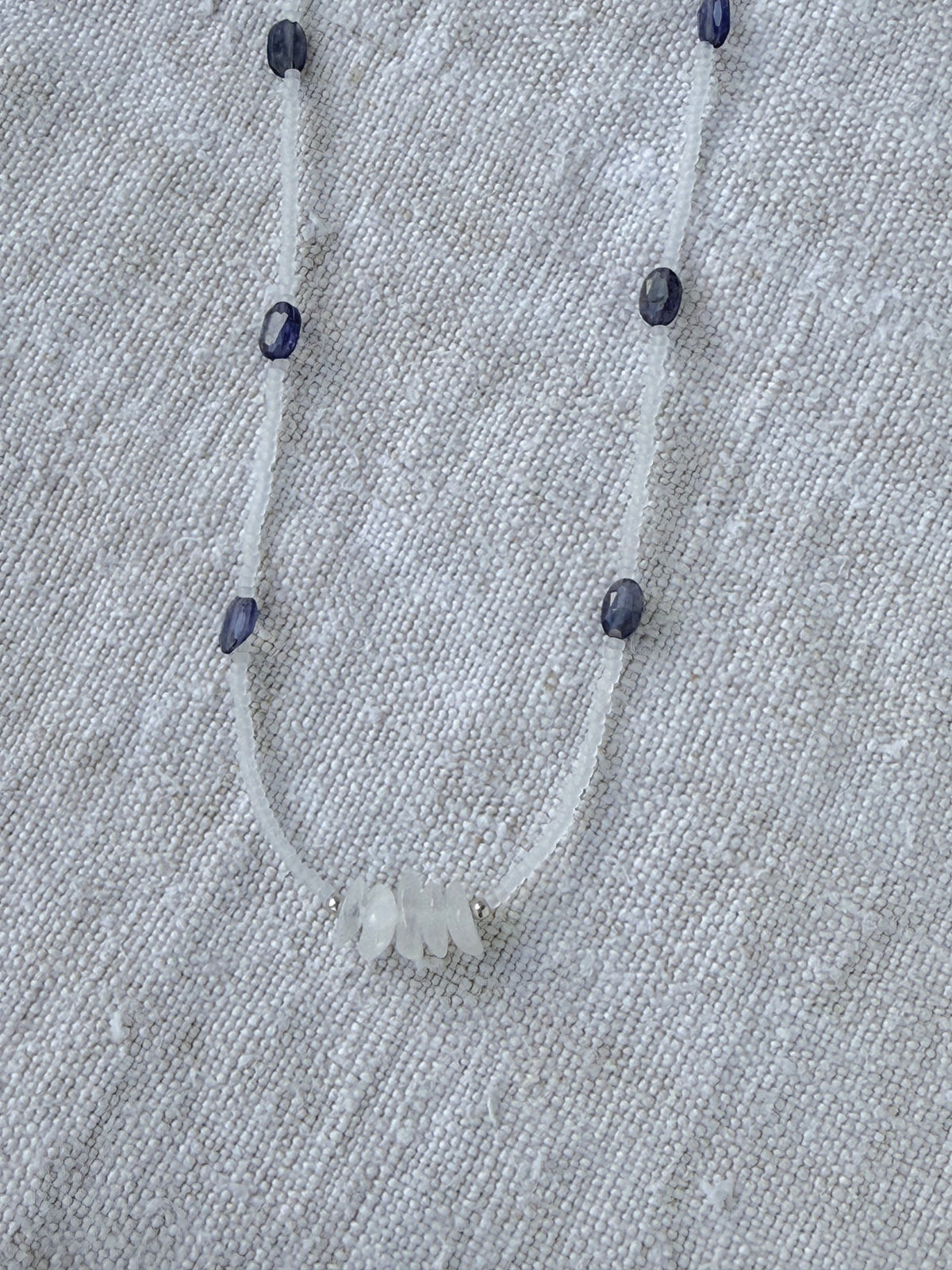 Détail du collier Brume : chips de pierre de lune blanche entre les iolites