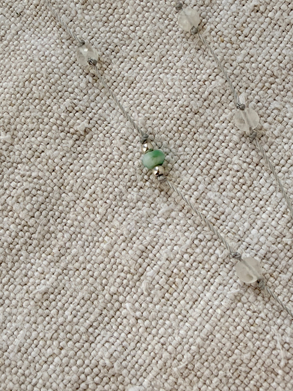 Détail du collier Brume long : turquoise verte entre deux perles argent et pierres de lune sur cordon gris