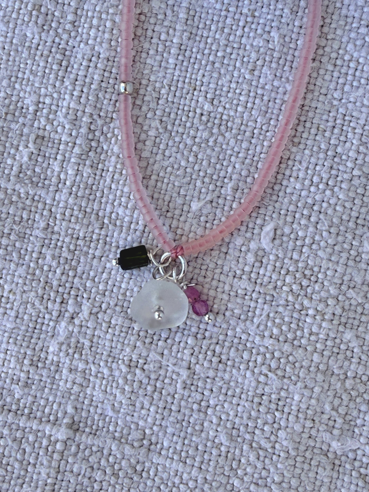 Détail des breloques du bracelet Bruyère : verre de mer, tourmaline verte et tourmalines roses