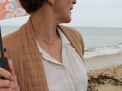 Collier lasso Bruyère porté au bord de la mer, perles roses et tourmalines vertes — fait main en Normandie