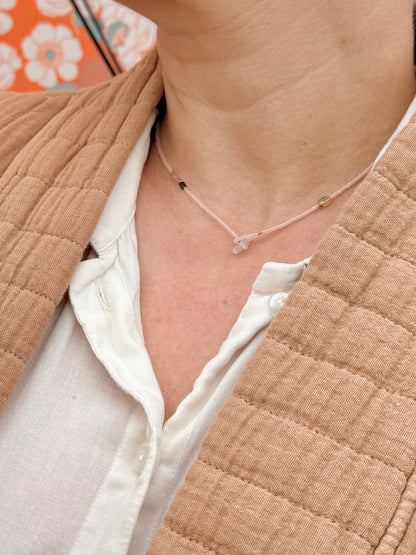 Collier court Bruyère porté de près, perles rose poudré et fermoir en verre dépoli