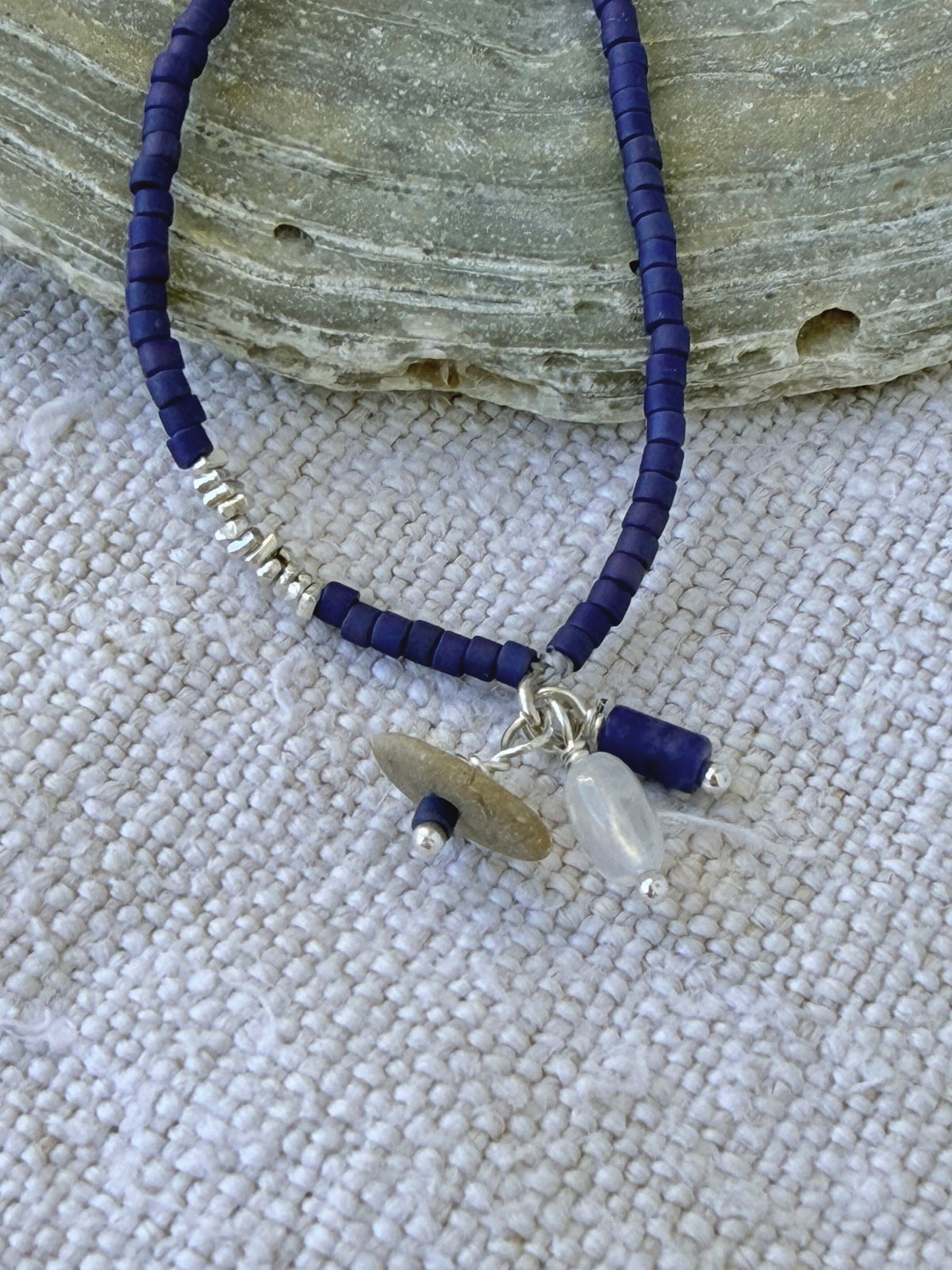 Détail du bracelet Embrun : breloques galet de plage, pierre de lune et sodalite sur perles indigo mat
