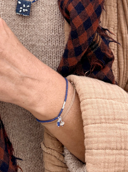 Gros plan sur le bracelet Embrun porté, breloques sodalite et pierre de lune sur perles bleu indigo