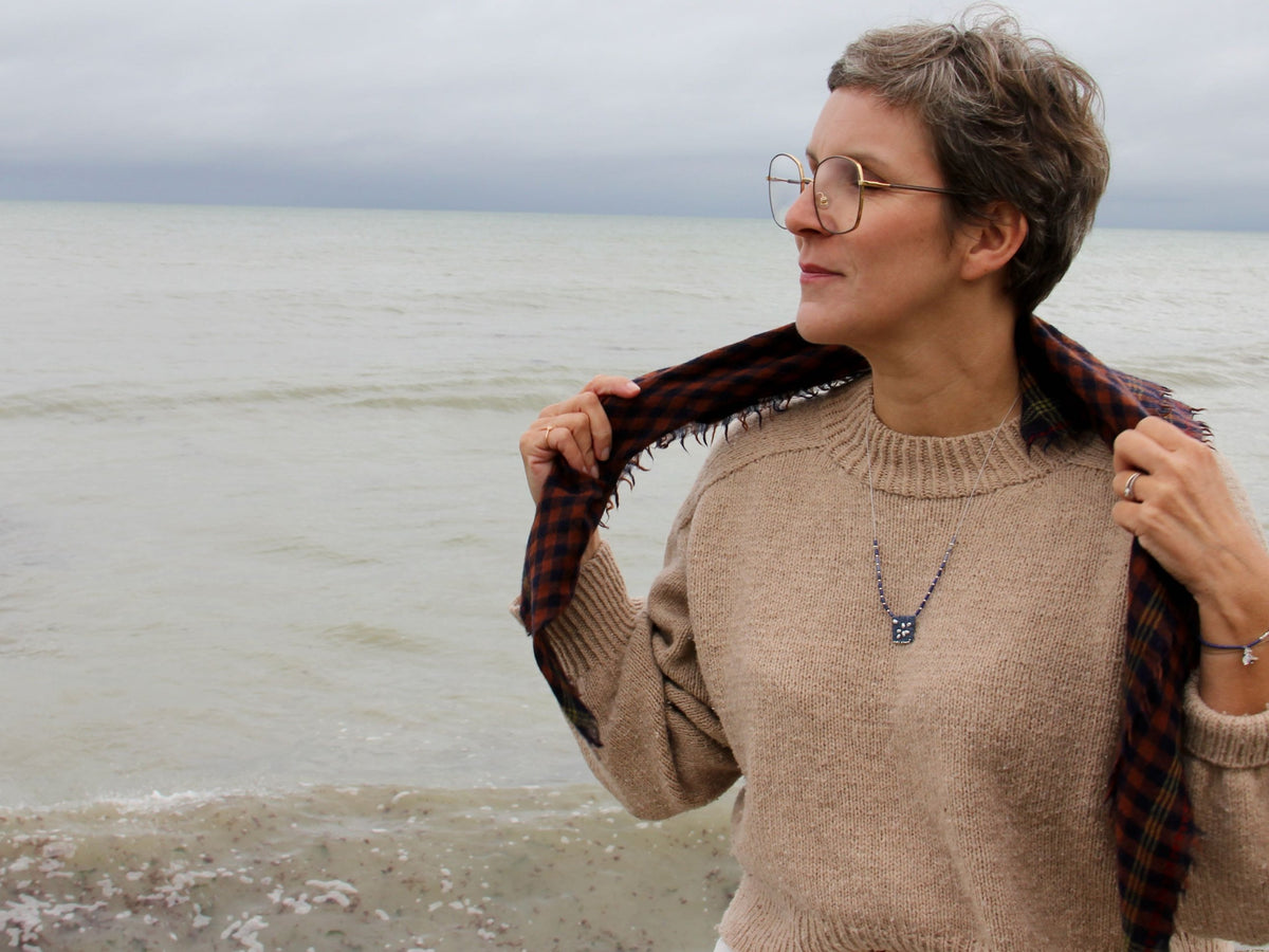 Collier Embrun porté avec une écharpe à carreaux au bord de la mer