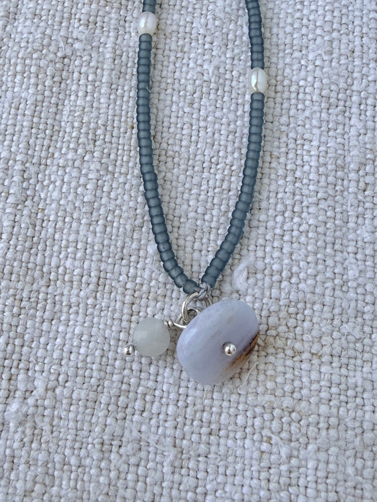 Détail du bracelet Jour de Pluie : galet de calcédoine bleue et pierre de lune mate sur perles gris bleuté