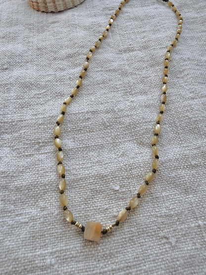 Collier Lichen en nacre olive posé sur du lin, bijou fait main en Normandie