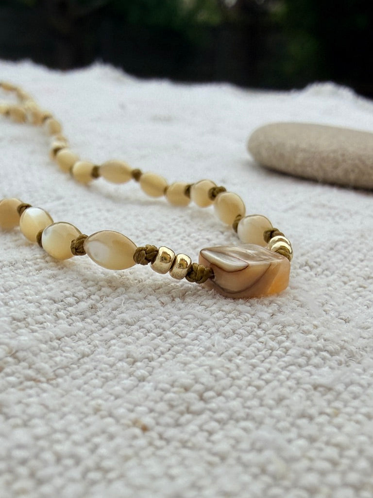 Gros plan sur les nacres nouées une à une du collier Lichen