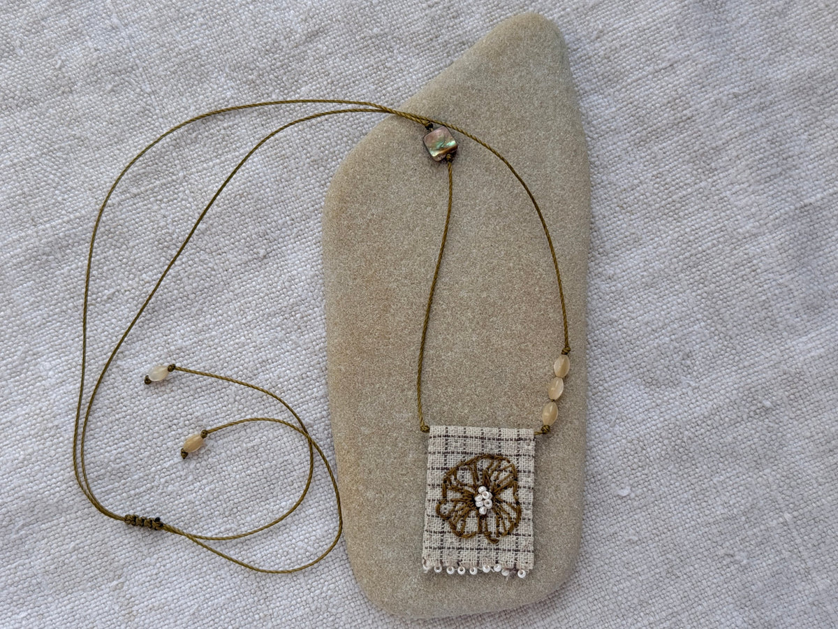 Collier Lichen médaille brodée posé sur un galet, fleur brodée main, nacres et abalone