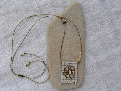 Collier Lichen médaille brodée posé sur un galet, fleur brodée main, nacres et abalone