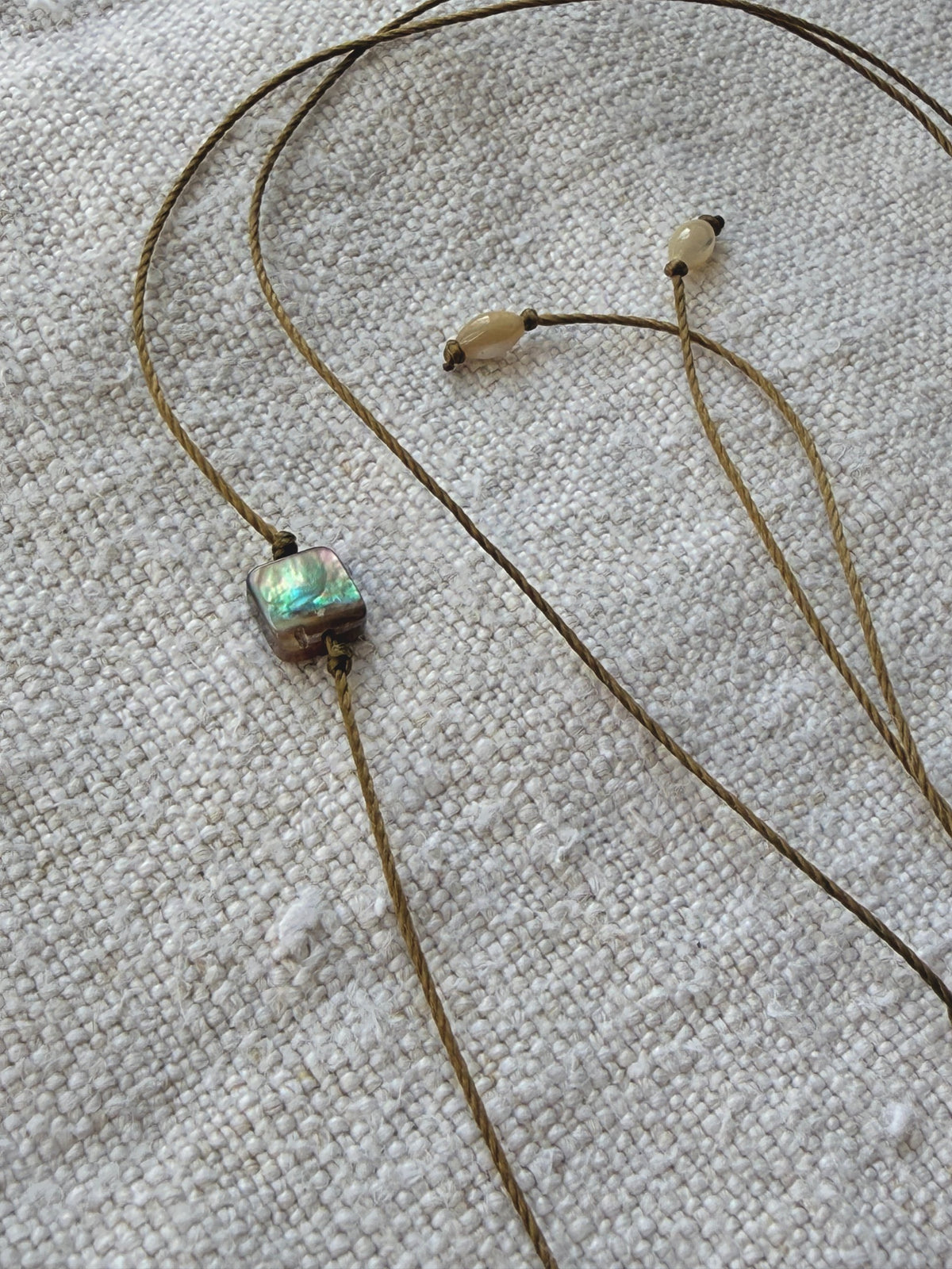 Détail du carré de nacre abalone et des nacres olive du collier Lichen brodé