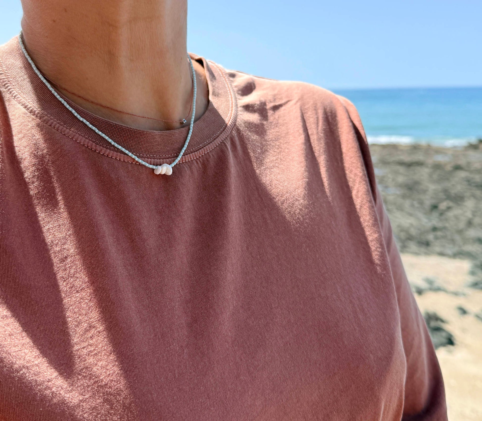 Collier fait main bleu porté avec une marinière, bijou artisanal Normandie