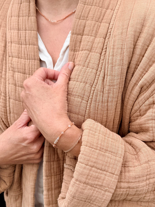 Bracelet et collier Tarte aux Pommes portés avec une veste camel, perles orange cuit et pierres de lune pêche