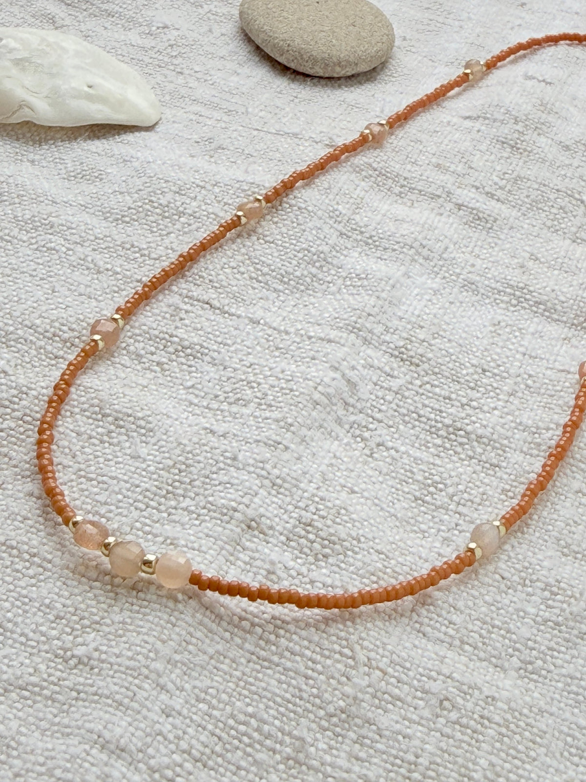 Détail des pierres de lune pêche facettées et perles dorées du collier Tarte aux Pommes