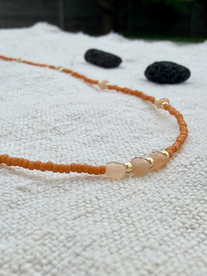 Gros plan sur le collier Tarte aux Pommes, perles Miyuki orange cuit et pierres de lune pêche