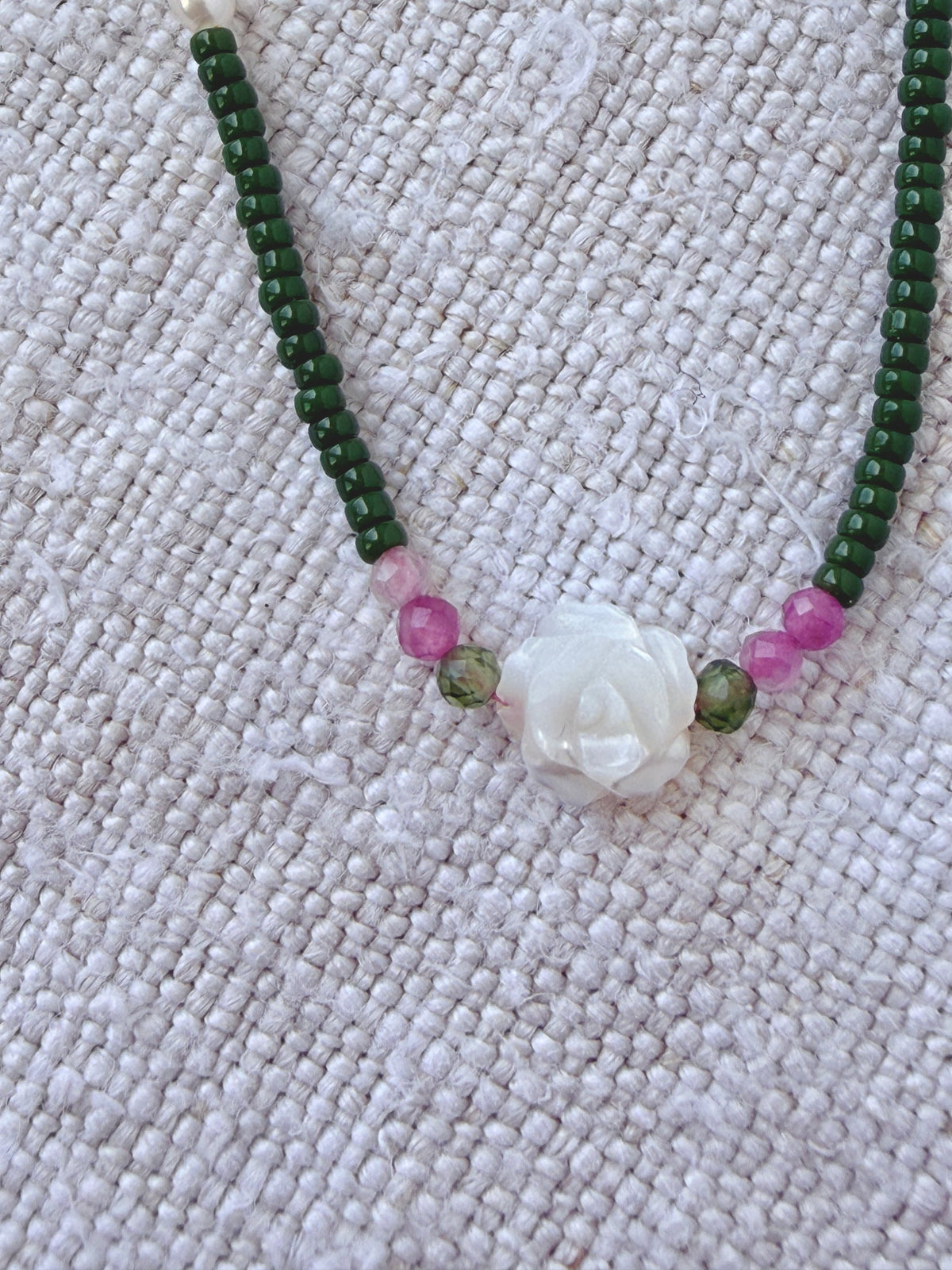 Détail du bracelet Veules : fleur de nacre sculptée entre des tourmalines rose et verte