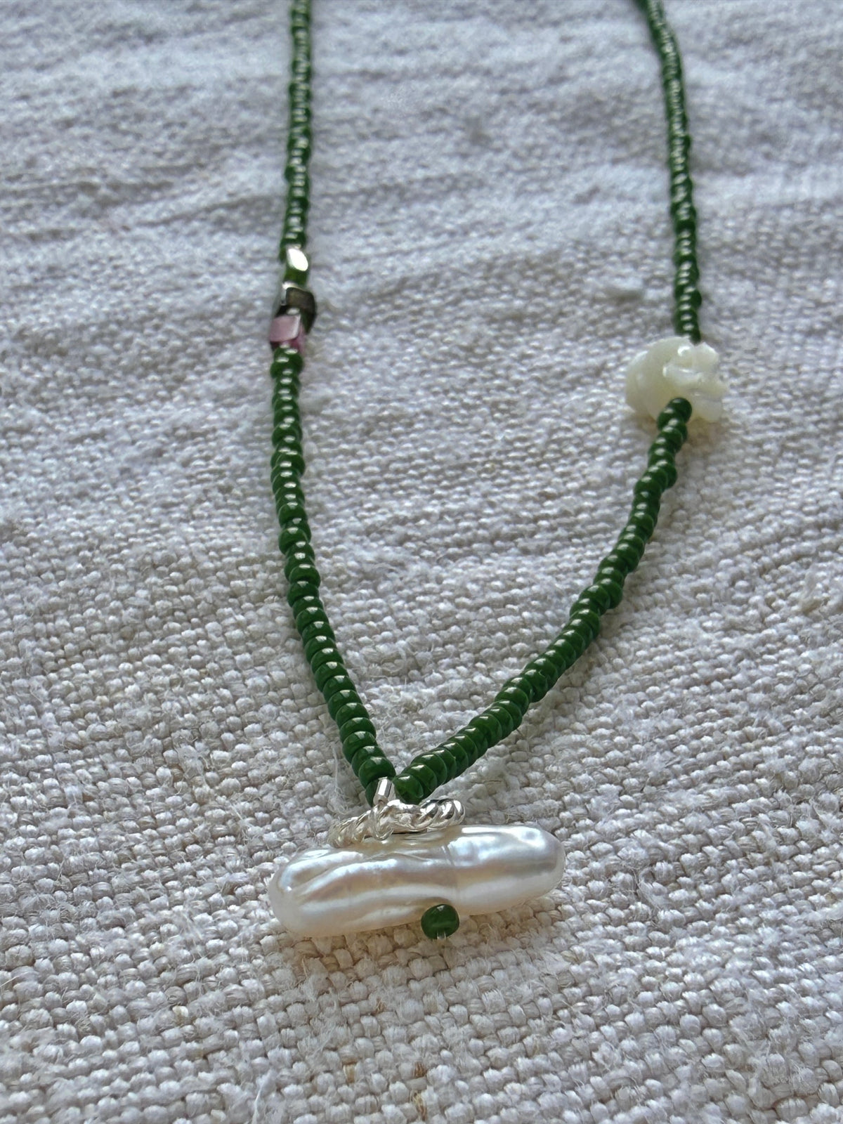 Détail du collier Veules : perle baroque et anneau torsadé argent, fleur de nacre et tourmalines rose et verte