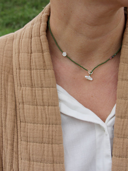 Gros plan sur le collier Veules porté : fleur de nacre, tourmalines et perle baroque sur anneau argent